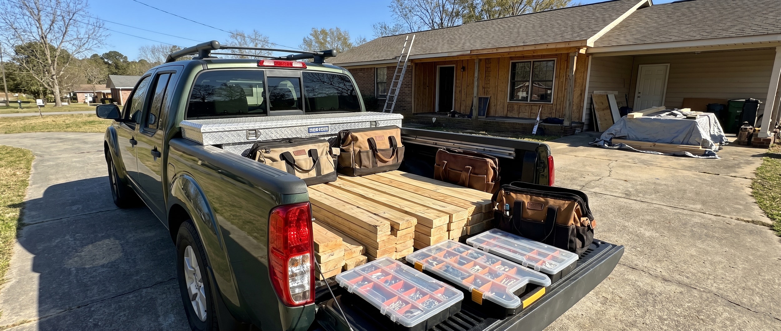 Nissan Frontier bed organized with lumber and tools for home improvement project in Birmingham, AL