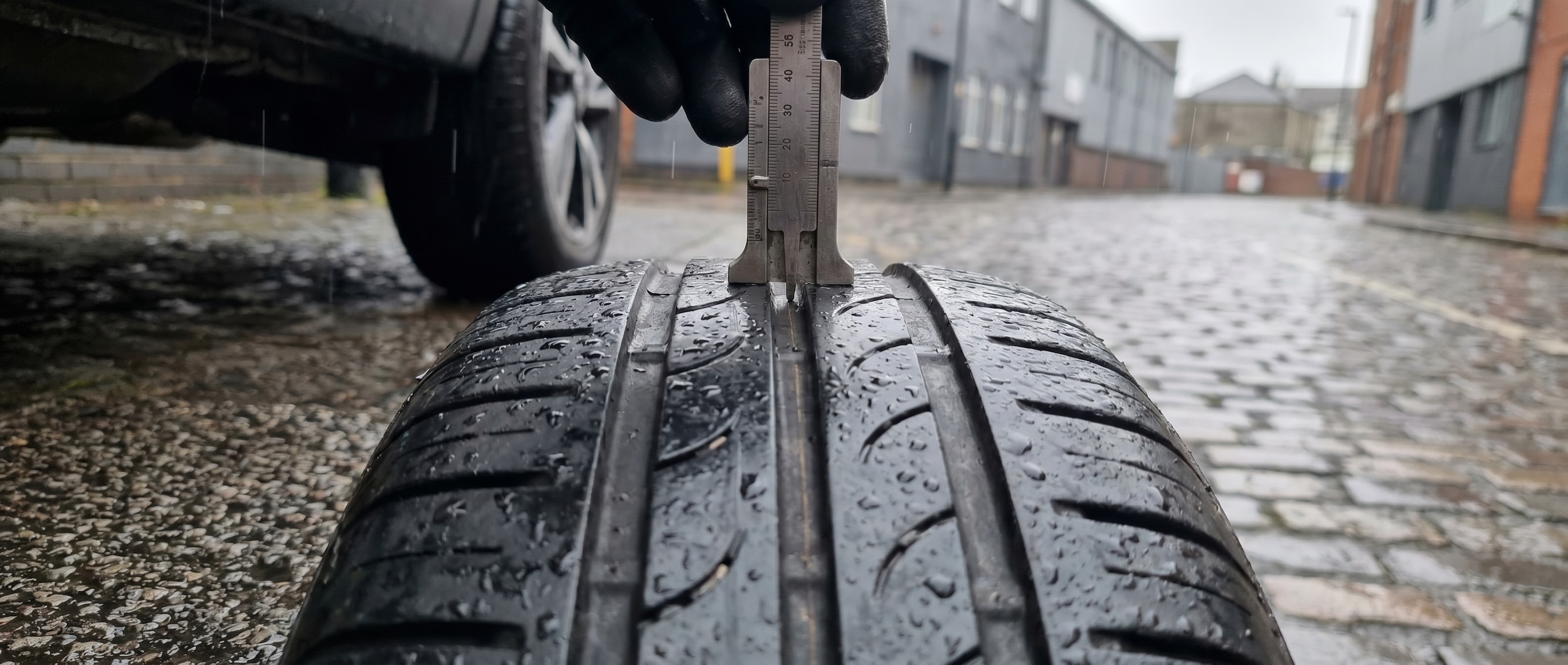 Tire tread depth test on Nissan vehicle in Birmingham AL rain conditions