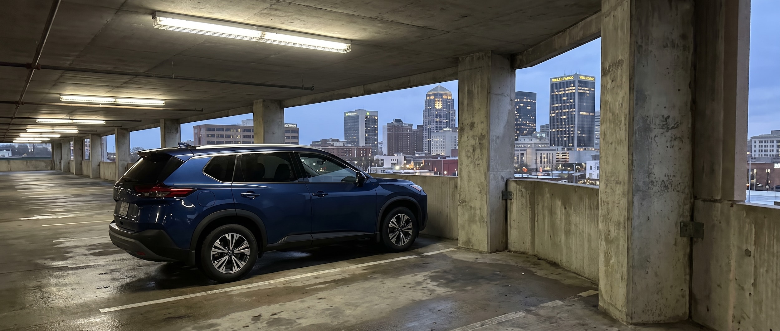 2026 Nissan Rogue parked in a downtown Birmingham parking garage with concrete pillars and city skyline in background