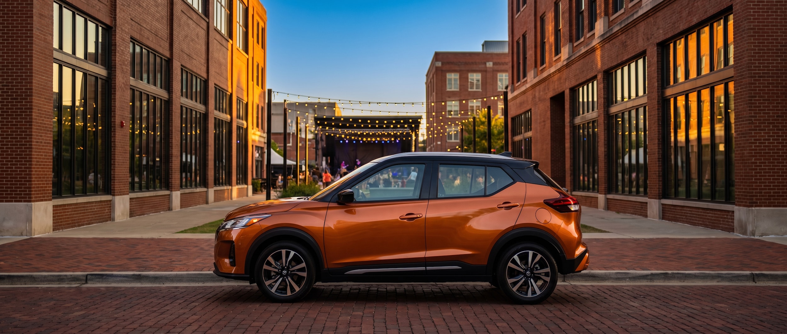 2026 Nissan Kicks parked on a downtown Birmingham street at dusk near City Walk BHAM