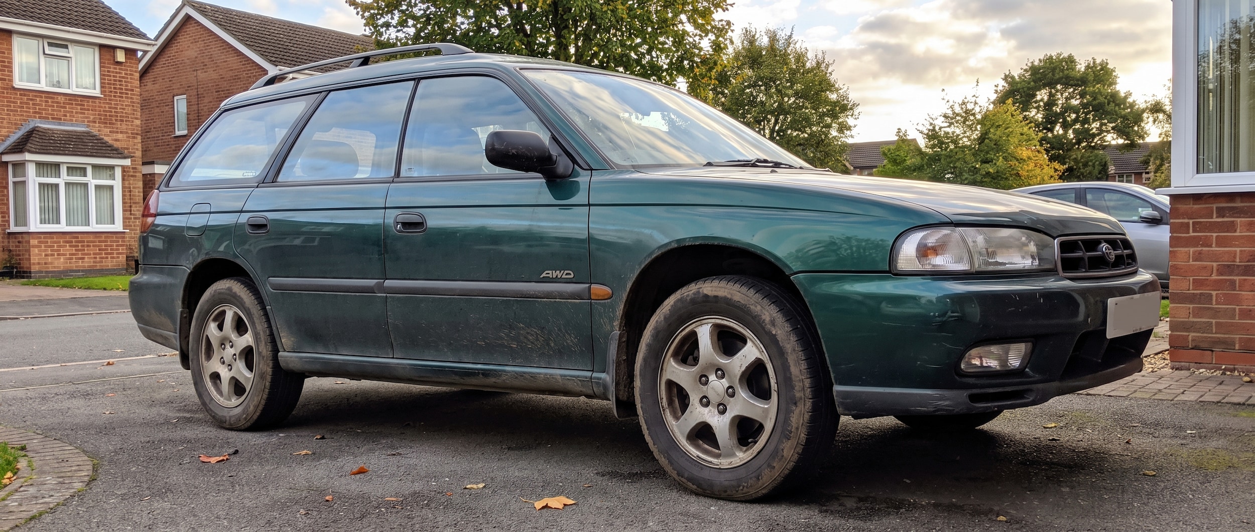 Used Subaru Outback parked in Birmingham AL driveway with matching tires visible, pre-purchase inspection checklist