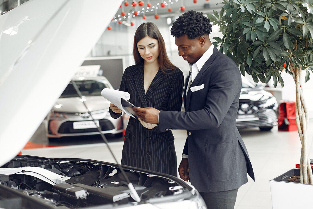 Looking at papers in front of a car.jpg