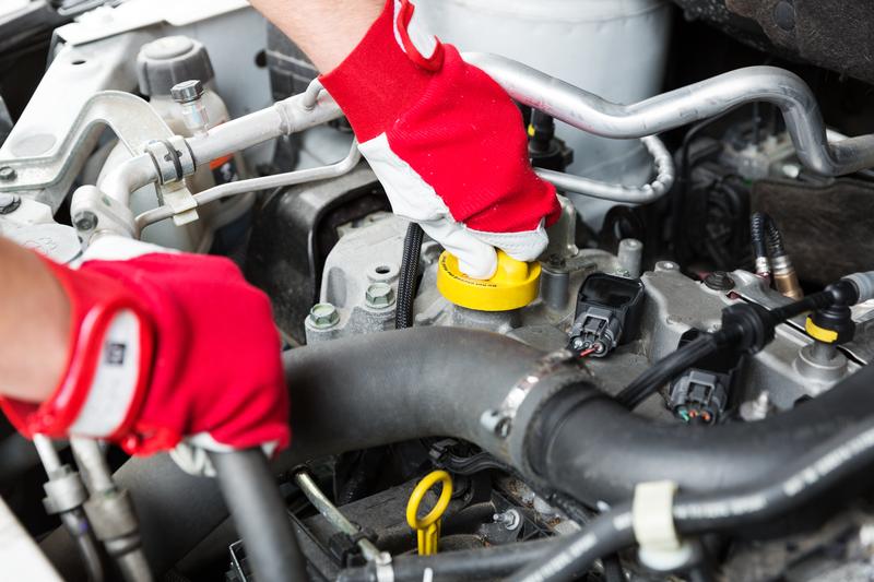 Picture of a mechanic doing service maintenance on a car.