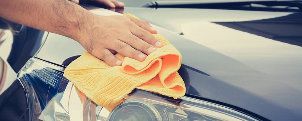 Person wiping headlight off with cloth