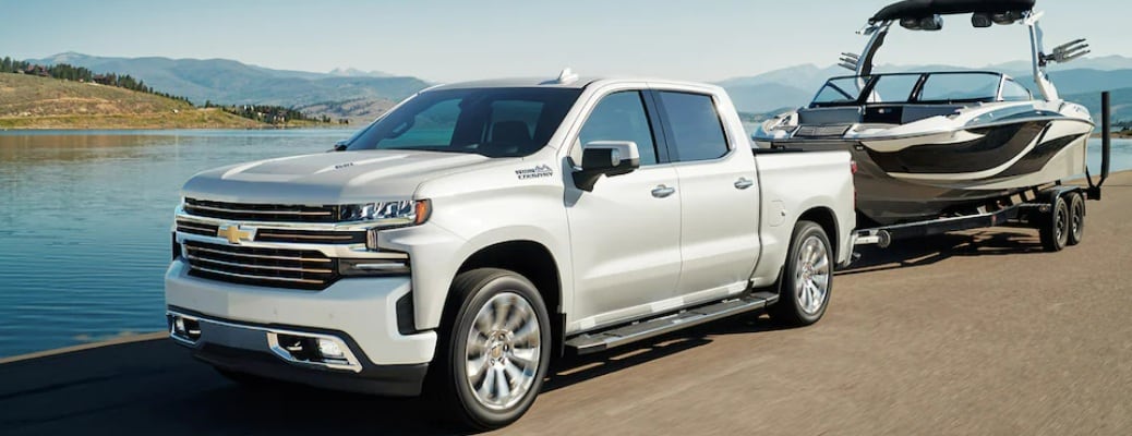 2022 Chevy Silverado 1500 white towing a boat side view_o