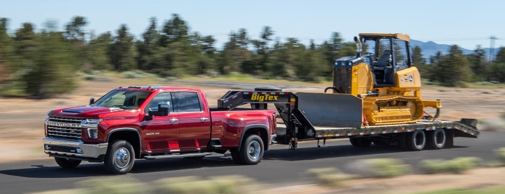 2022 Chevy Silverado 3500 HD red side towing construction equipment