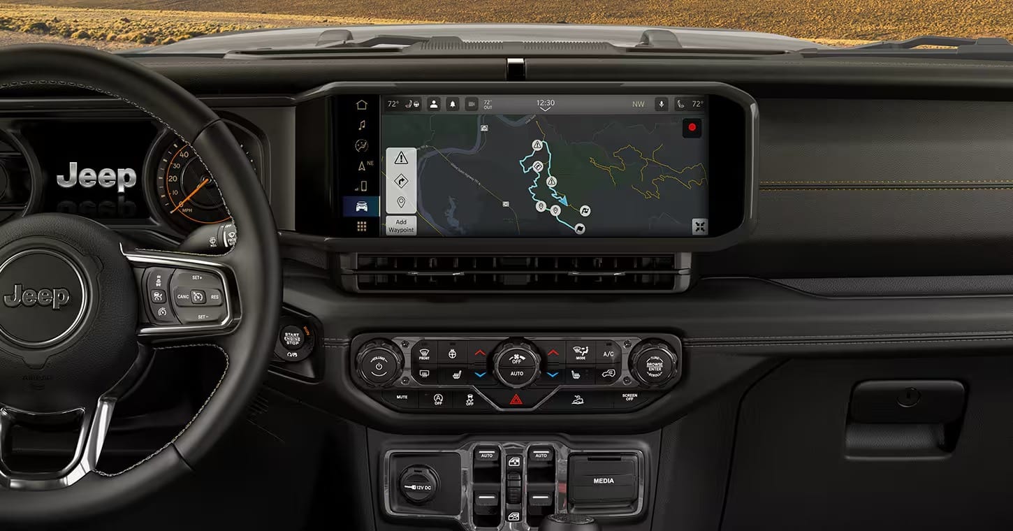 A 2026 Jeep Wrangler parked with a scenic view of the Olympic Mountains in the background.