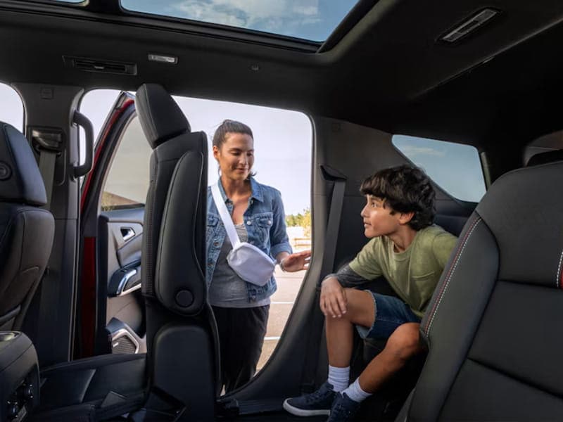 Mother and son checking out the rear seat of a Chevrolet SUV