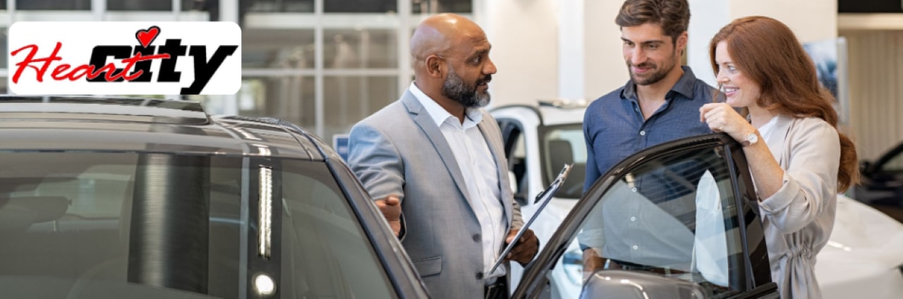 Close-up of a Heart City Toyota staff member assisting a customer with a car payment calculator at the dealership.