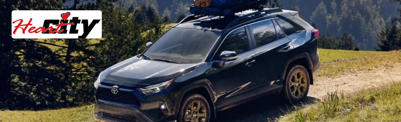 Go-Further-with-the-Toyota-RAV4-Hybrid.png Heart City Toyota dealership in Elkhart, IN, showcasing a lineup of Toyota RAV4 Hybrid SUVs.