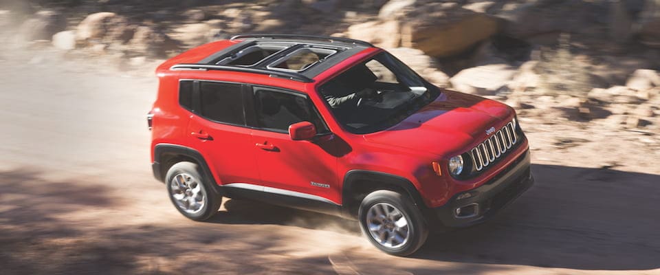 A red 2018 Jeep Renegade driving through the desert