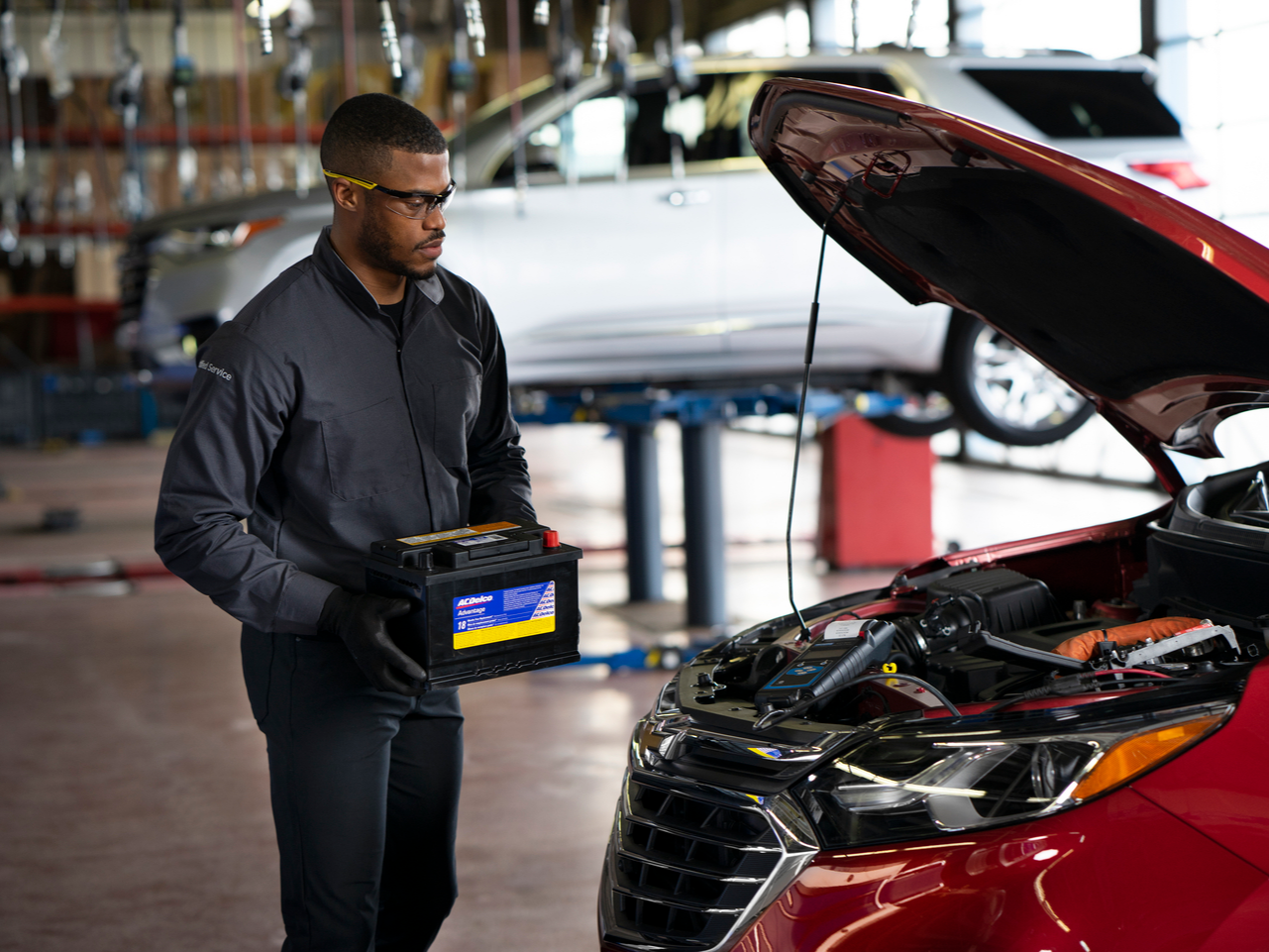 Chevrolet Service staff placing a battery for a red Chevrolet
