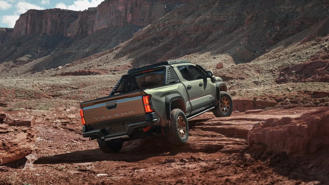 2026 Toyota Tacoma driving through a Pacific Northwest setting, emphasizing its capability.