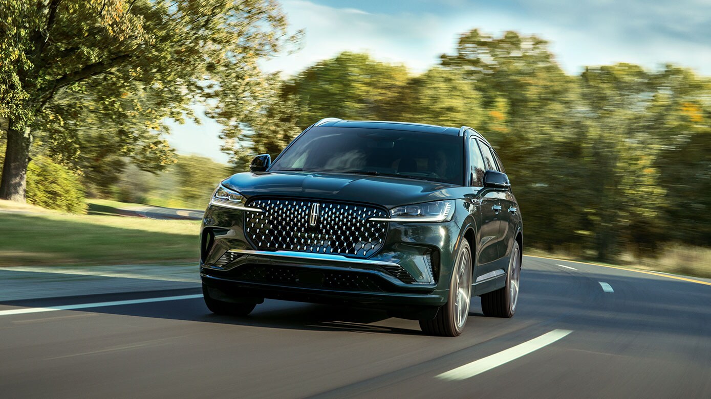 green Lincoln Aviator driving in countryside