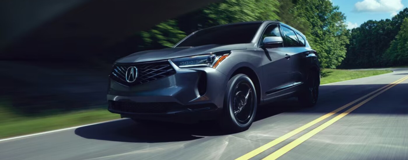 Grey 2026 Acura RDX driving down an open road