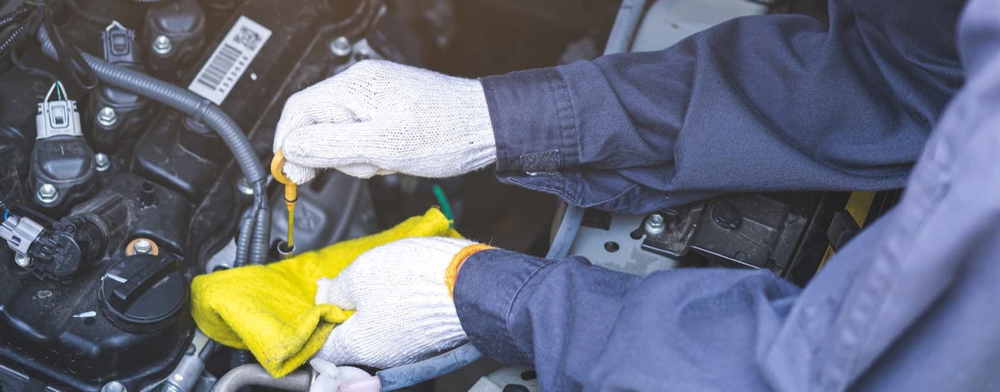 A mechanic holding a cloth and a dipstick.