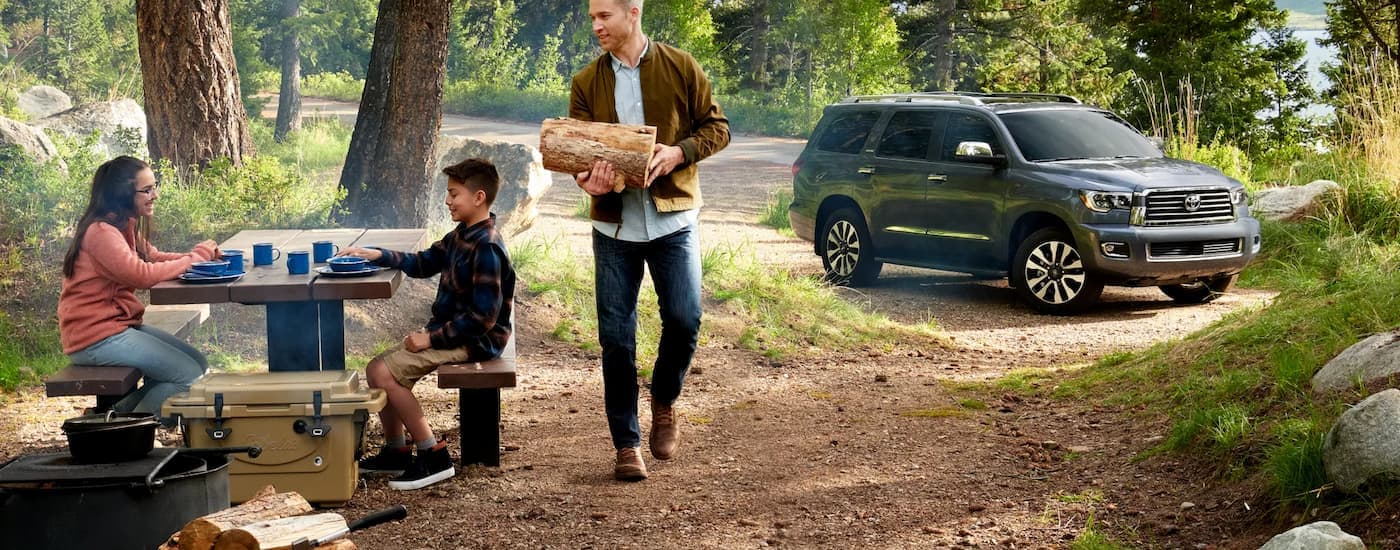 A grey 2022 Toyota Sequoia is shown parked near a campsite.