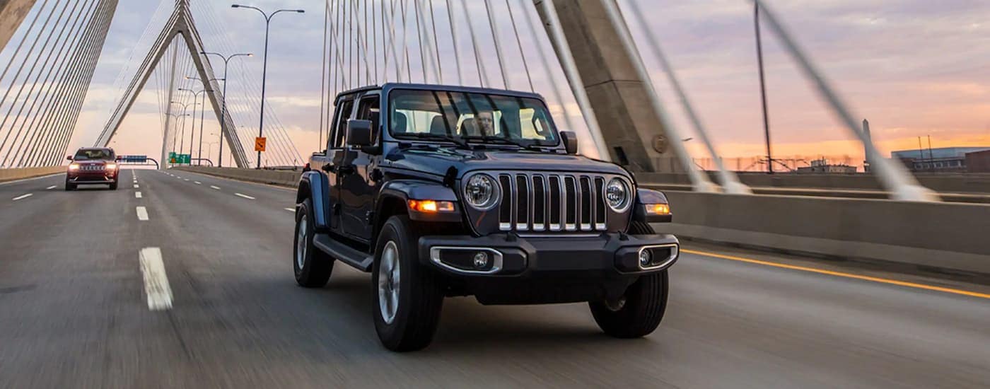 A black 2023 Jeep Wrangler is shown on a test drive at a used car dealership near Charlotte.