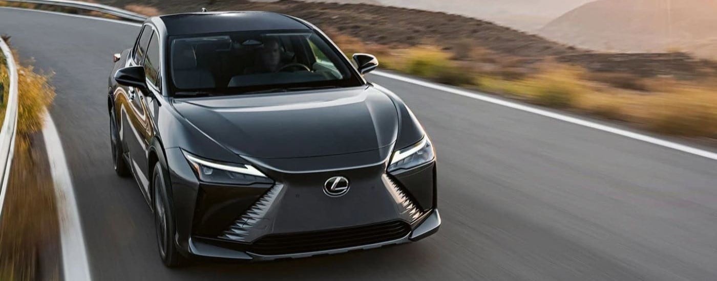 A back 2023 Lexus RZ is shown rounding a corner after leaving a car dealership near Raleigh, NC.