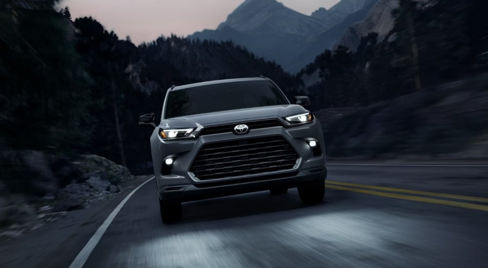 Grey 2026 Toyota Grand Highlander Hybrid Nightshade driving at night