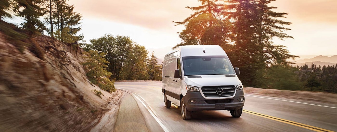 A 2025 Mercedes-Benz Sprinter cargo van is shown driving to view cargo vans for sale in Charlotte.
