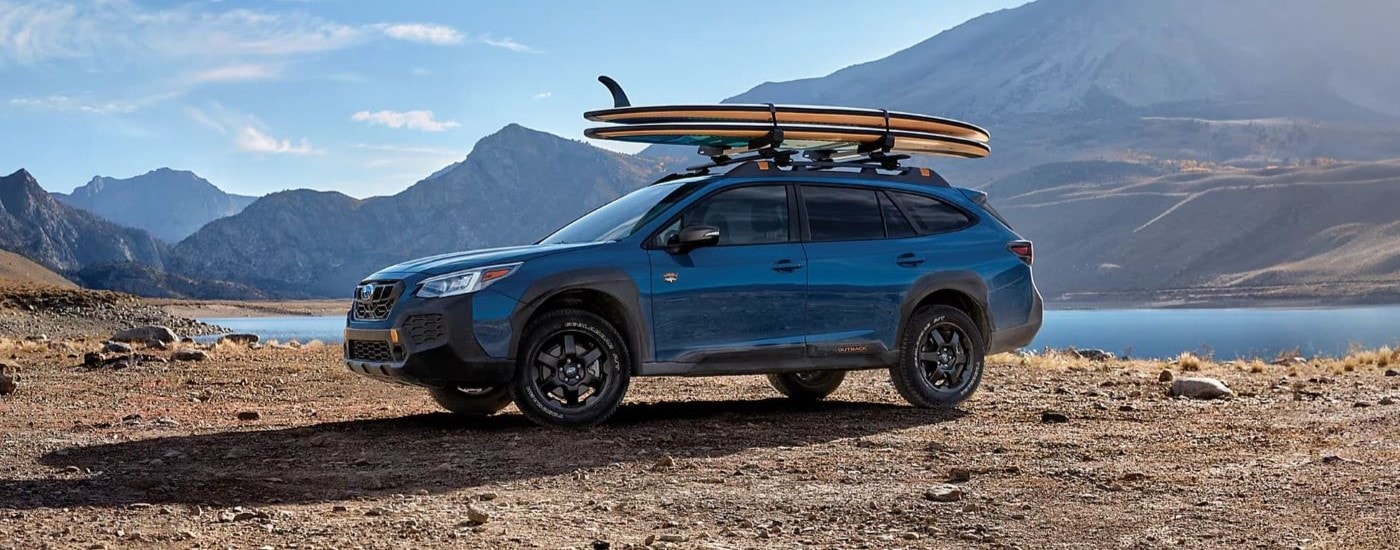 Blue 2024 Subaru Outback Wilderness parked near a lake