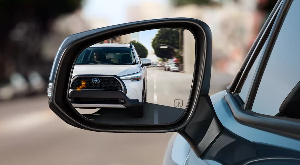 White 2024 Toyota Corolla Cross in the side mirror of a vehicle