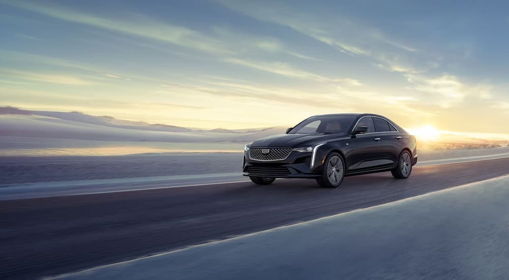 Black 2025 Cadillac CT4 driving from a car dealer near Matthews.