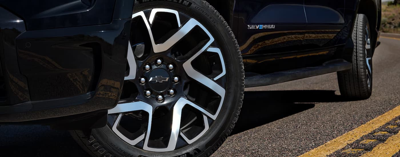 A close up of the side of a black 2025 Chevy Silverado EV at a car dealer near Norcross.