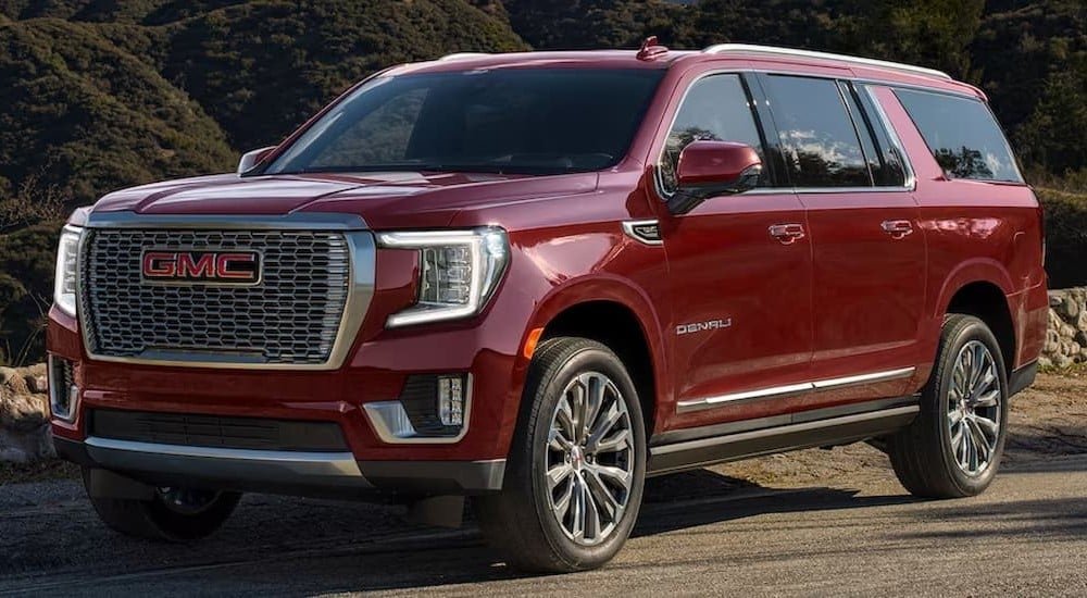 A red 2023 GMC Yukon Denali is shown parked off-road.