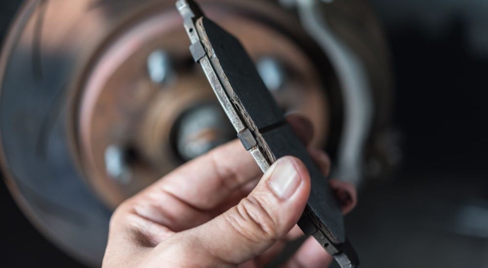 A close-up shows a worn brake pad.
