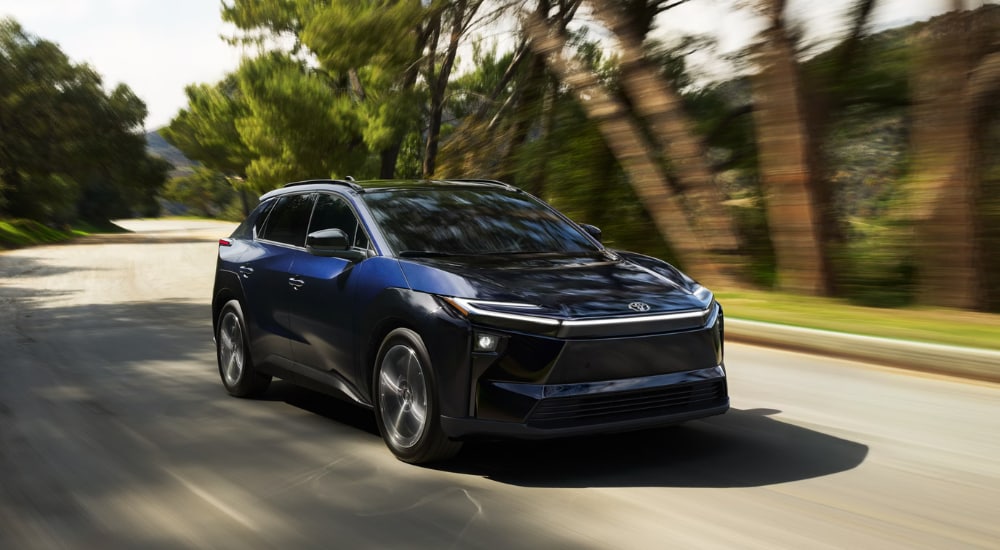 Blue 2026 Toyota bZ driving down a residential street