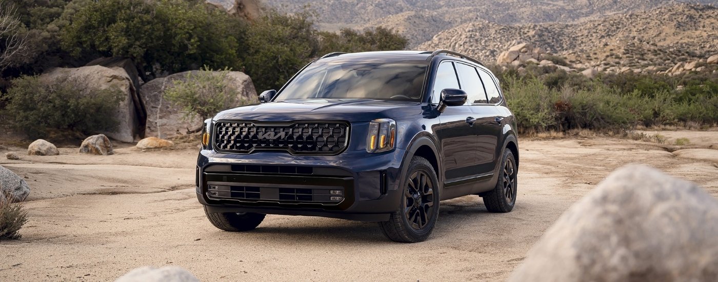 Blue 2025 Kia Telluride driving off-road