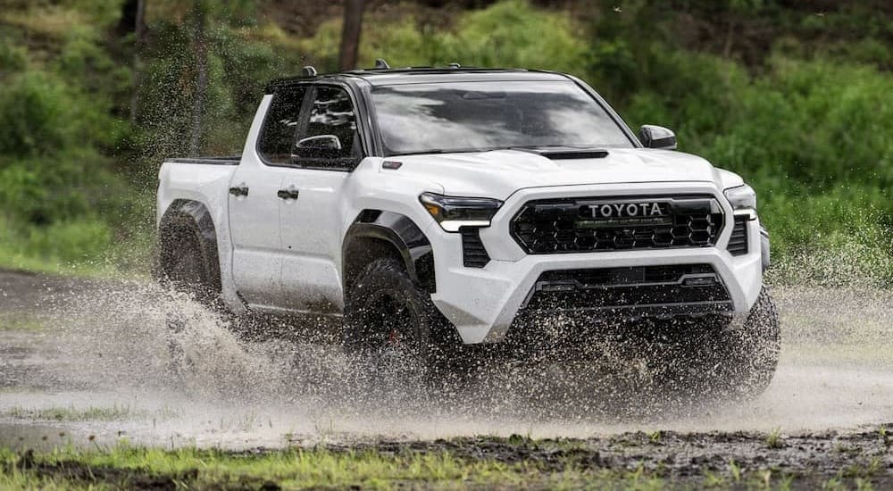 A white 2024 Toyota Tacoma TRD Pro is shown driving through water.