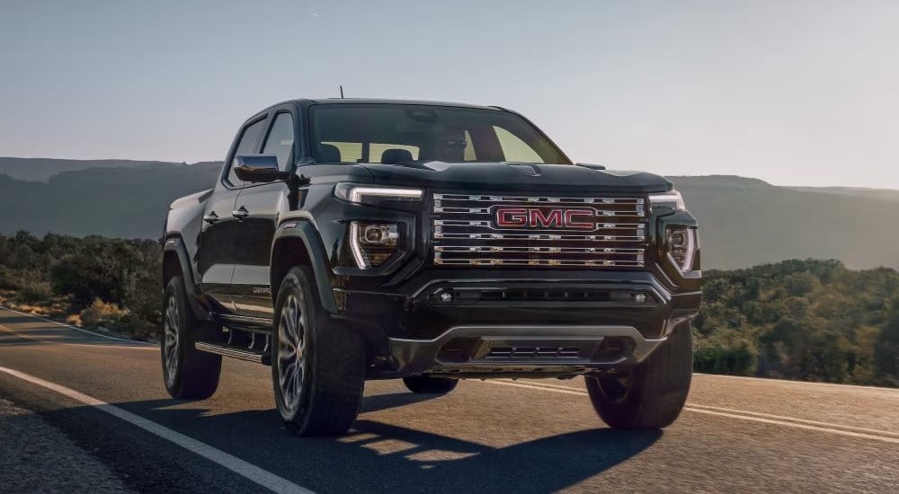 Used%20Vehicles%20for%20Sale%20Near%20Me%20-%202023%20GMC%20Canyon%20Denali%20-%20Drive%202.jpg A black 2023 GMC Canyon Denali is shown driving on a highway.