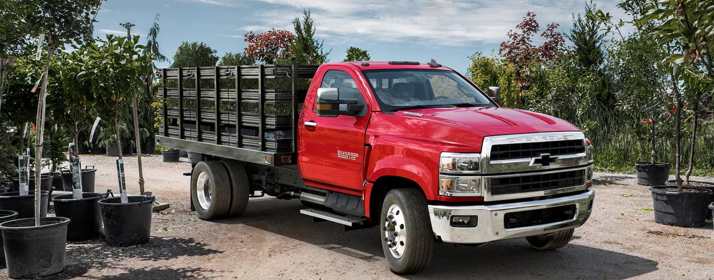 A red 2024 Chevy Silverado 5500 HD parked near a commercial truck dealer in Charleston.
