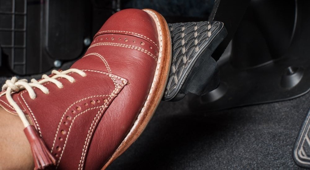 A close-up shows a brake pedal being depressed.