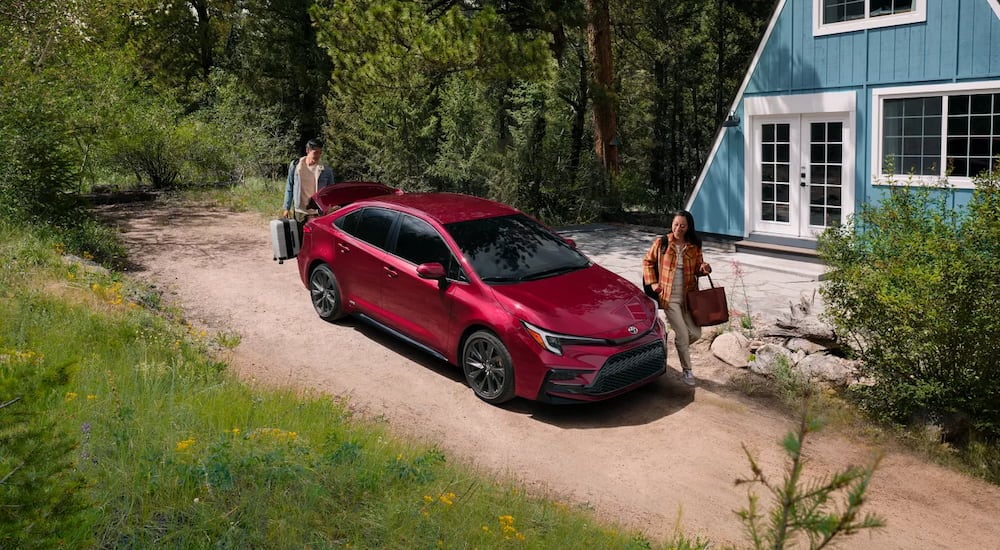 Red 2026 Toyota Corolla parked on a driveway outside a house.