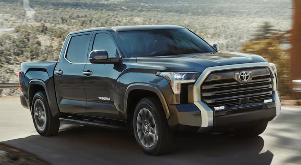 A black 2026 Toyota Tacoma driving down a road