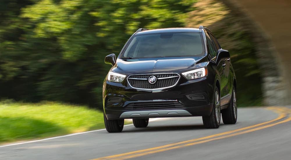 A black 2022 Buick Encore is shown driving on a highway after visiting a used car dealership near Wilmington.