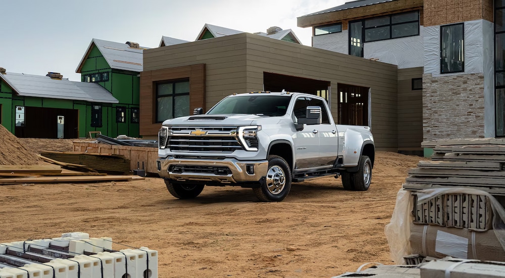 A white 2024 Chevy Silverado 3500 HD dually parked at a construction site.