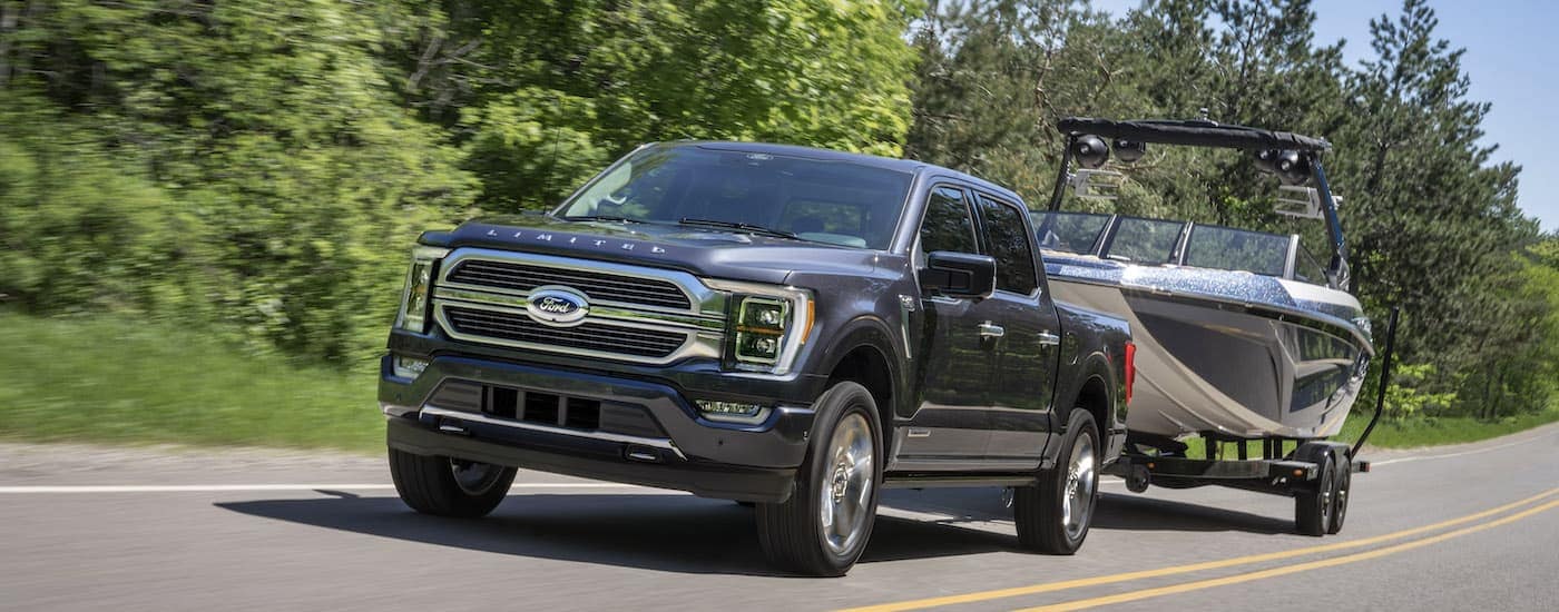 A grey 2022 Ford F-150 Limited is shown from the front while towing a boat.