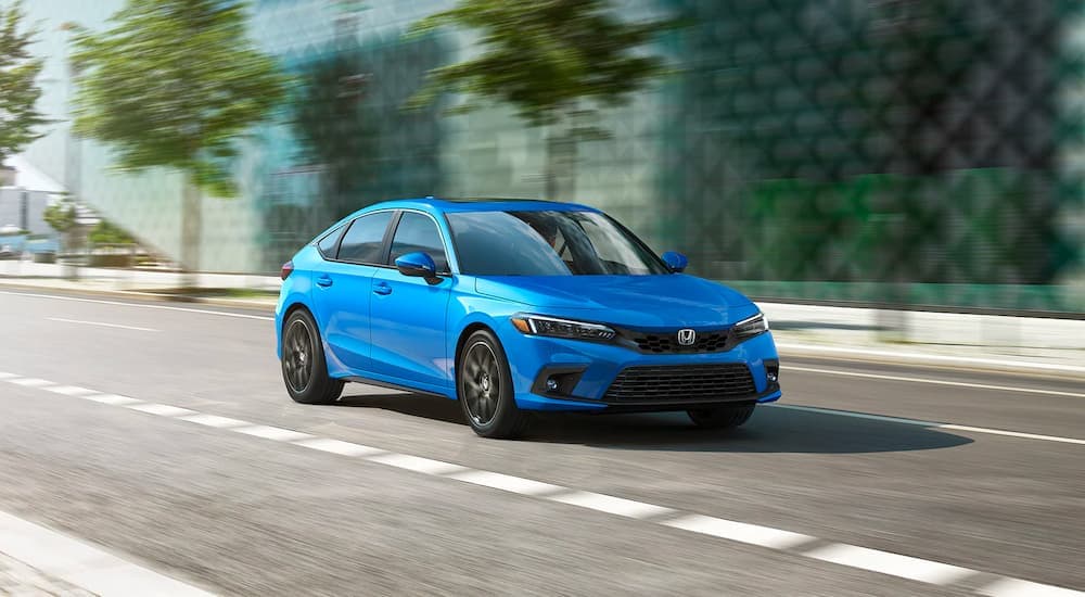 Blue 2023 Honda Civic driving on a city street