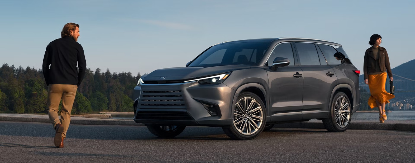 Grey 2026 Lexus GX with two people walking around it