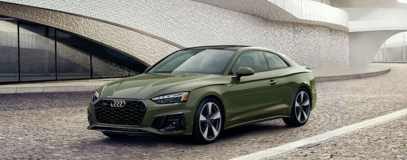 A green 2020 Audi A5 parked in a courtyard.
