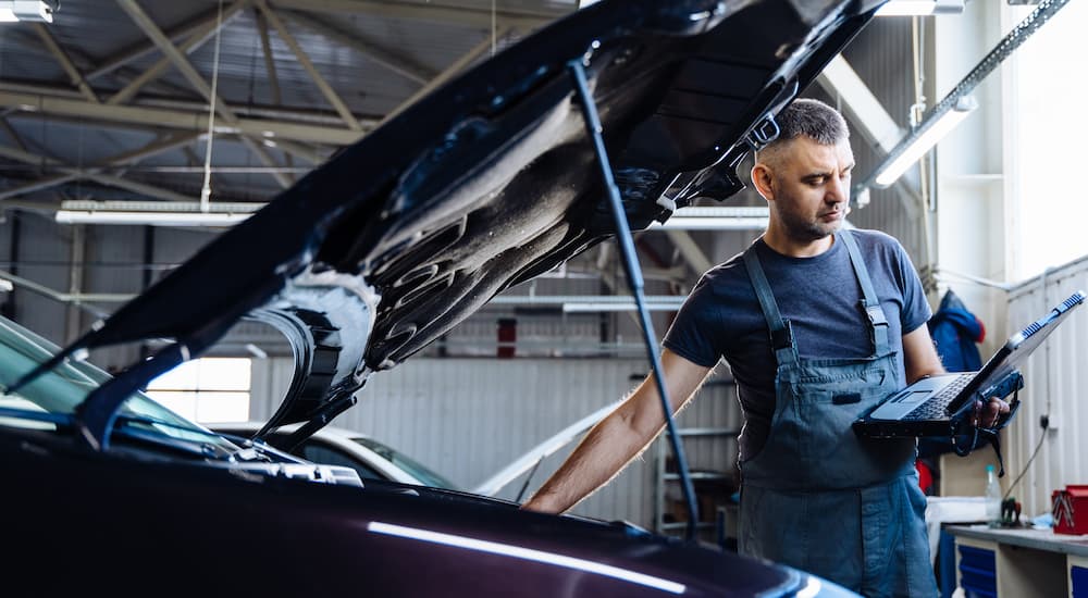 A mechanic is inspecting the engine of a vehicle at a service center near Charlotte.