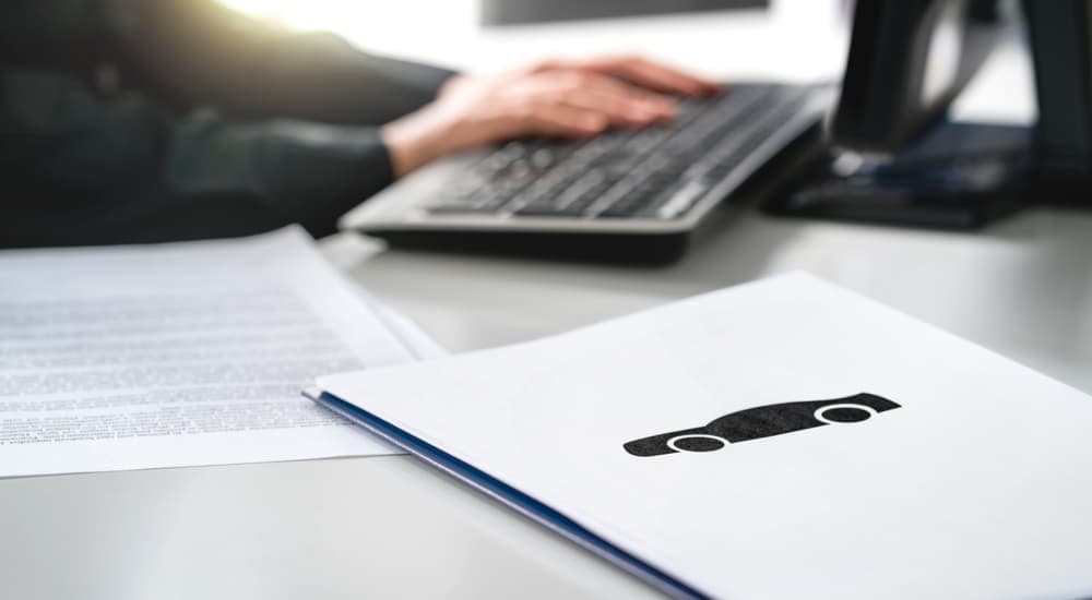 Salesman doing paperwork for cars for sale near Goose Creek