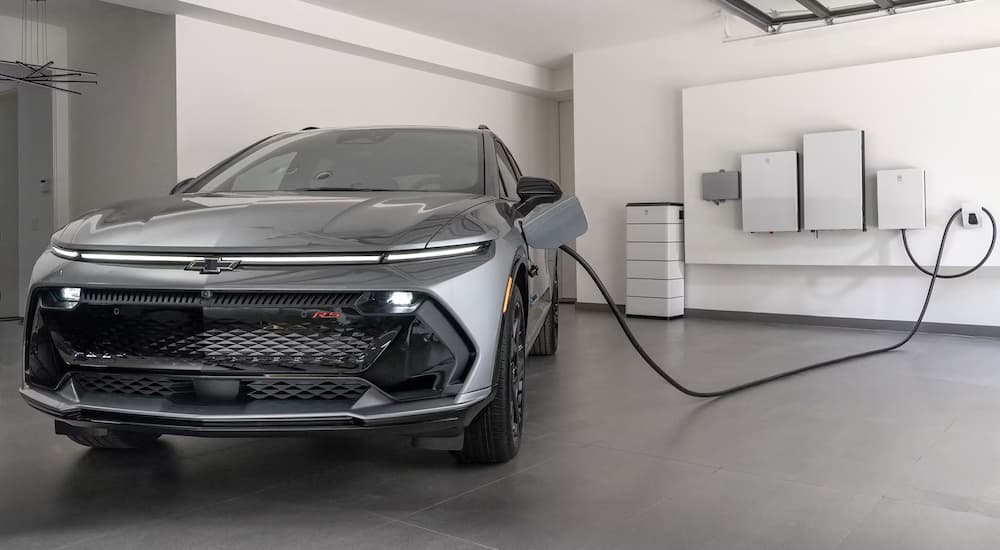 A gray 2026 Chevy Equinox EV plugged in charging