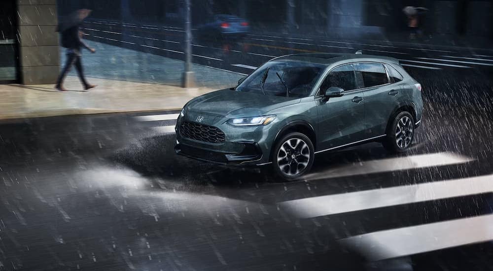 Grey 2026 Honda HR-V driving across an intersection.