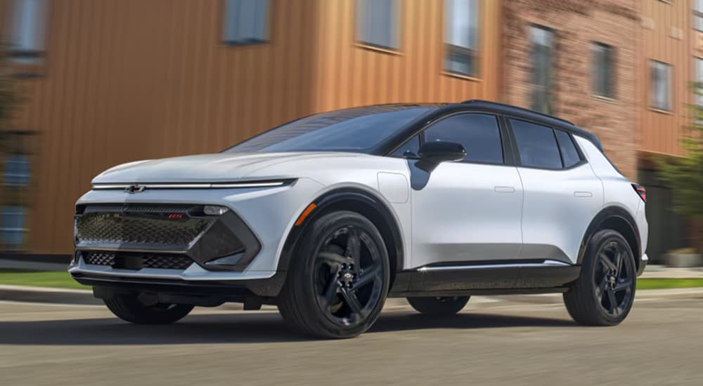 White 2026 Chevy Equinox EV RS driving to see SUVs for sale